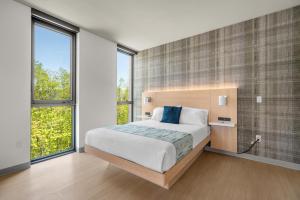 a bedroom with a large bed and large windows at The Simon at Simon Fraser University in Burnaby