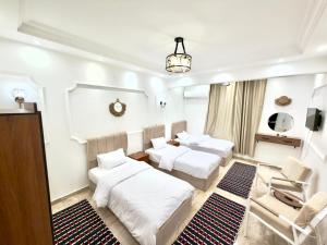 a living room with three beds and a couch at TriPyramids Suites in Cairo +34 photos