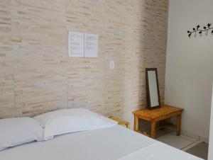 a bedroom with a white bed and a mirror at Pousada Kaa - Natureza e Sossego em Itacaré in Itacaré