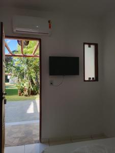 a room with a flat screen tv on a wall at Pousada Kaa - Natureza e Sossego em Itacaré in Itacaré