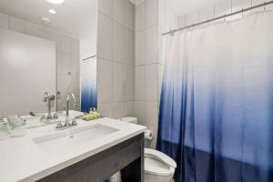 a bathroom with a sink and a blue shower curtain at The Simon at Simon Fraser University in Burnaby +21 photos