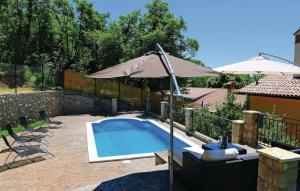 a swimming pool with an umbrella and a table and chairs at Villa Nina Labin-The oasis of peace in Labin