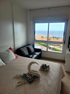 a bedroom with a bed with a couch and a large window at Super Penthouse Ocean View in San Miguel de Abona +39 photos