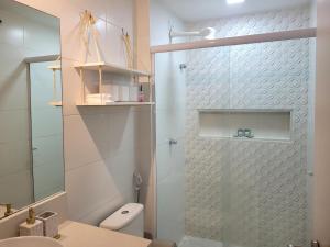 a bathroom with a shower with a toilet and a sink at Flat Praia Itacoatiara in Niterói +19 photos