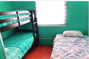 a bedroom with two bunk beds and a bed at Cabañas "Parada Tentelhué" in Rolecha
