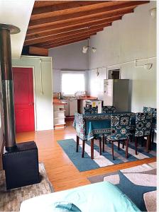 a living room with a dining table and a kitchen at Cabañas "Parada Tentelhué" in Rolecha