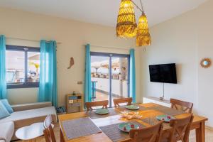 a living room with a dining room table and a television at Cotillo Jolanda in El Cotillo