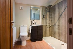 a bathroom with a toilet and a shower and a sink at Crown Lodge Hotel in Wisbech