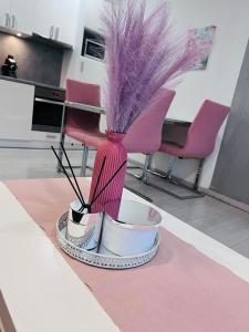 a table with a tray with a vase with feathers at Basilica Apartments in Budapest +6 photos