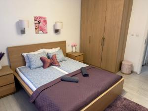 a bedroom with a bed with purple sheets and pillows at Basilica Apartments in Budapest