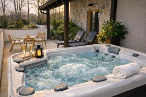 a jacuzzi tub in the middle of a patio at Plitvice Falls Cottage - Luxury rooms & Dinner in Plitvica Selo