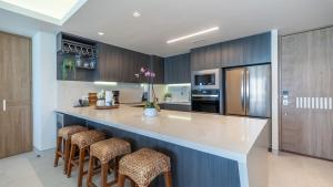 a kitchen with a large counter with stools in it at Modern Seaside Retreat Boasting Unforgettable Scenery in Puerto Peñasco
