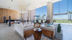 a living room with white furniture and large windows at Modern Seaside Retreat Boasting Unforgettable Scenery in Puerto Peñasco