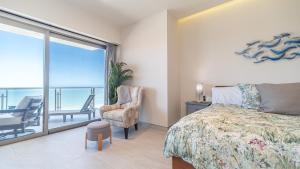 a bedroom with a bed and a chair and a balcony at Elegant Ocean Getaway Designed for Relaxation and Luxury in Puerto Peñasco +27 photos