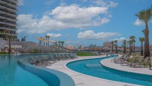 a swimming pool with lounge chairs and a resort at Elegant Ocean Getaway Designed for Relaxation and Luxury in Puerto Peñasco