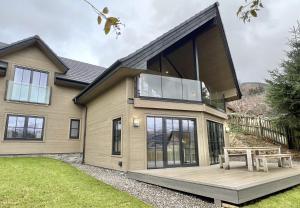 a house with a large window on a deck at Highland House in Lochearnhead