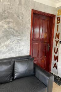 a black couch in front of a red door at Binyuma Suites Motel in Kampala +4 photos