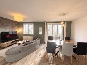 a living room with a couch and a tv at Le Robespierre - Parking privé - 5min gare in Reims