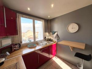 a kitchen with a sink and a clock on the wall at Le Robespierre - Parking privé - 5min gare in Reims +4 photos