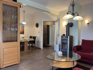 a living room with a red couch and a fireplace at Ferienhaus in Lindern mit Garten & Terrasse in Werlte