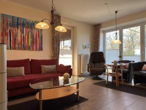 a living room with a red couch and a table at Ferienhaus in Lindern mit Garten & Terrasse in Werlte
