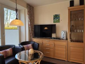 a living room with a television and a table and chairs at Ferienhaus in Lindern mit Garten & Terrasse in Werlte +28 photos