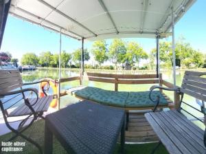 a porch with two benches and a table on a boat at Péniche Logement privé 2 chambres in Montech