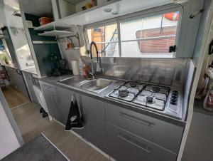a kitchen with a sink and a stove at Péniche Logement privé 2 chambres in Montech
