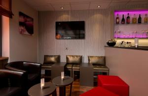 a bar with leather chairs and a red stool at Leonardo Hotel Nürnberg in Nuremberg +26 photos