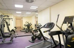 a gym with several treadmills and exercise bikes at Leonardo Hotel Weimar in Weimar