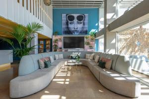 a living room with a large couch and a flat screen tv at Leonardo Boutique Hotel Mallorca Port Portals - Adults only in Portals Nous