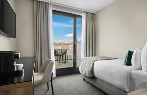 a hotel room with a bed and a balcony at Leonardo Hotel Vienna City West in Vienna