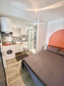a bedroom with a bed and a bathroom with a shower at Studio Bleu tout équipé au calme proche des commerces in Briord