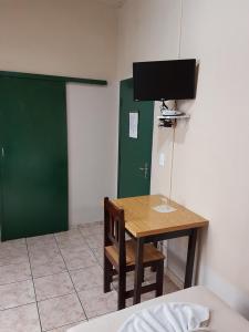 a room with a table and a green door at Hotel Bavarium in Joinville
