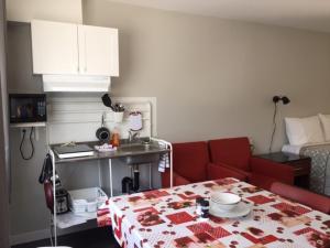 a living room with a red couch and a table at Motel Domaine Expédition in Labelle +12 photos