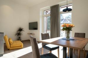 a dining room with a table and a vase of flowers at Villa Rosengarten Guesthouse in Merano
