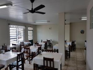 comedor con mesas y sillas y ventilador de techo en Hotel Bavarium, en Joinville