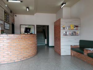 a room with a red brick wall and a counter at Hotel Bavarium in Joinville