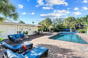 a patio with blue chairs and a swimming pool at Siesta SunDaze - 5430 in Sarasota