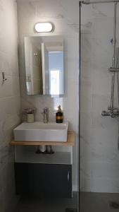 a bathroom with a sink and a mirror at Афіни Лофт in Piraeus
