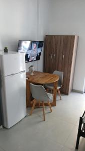 a kitchen with a wooden table and a refrigerator at Афіни Лофт in Piraeus