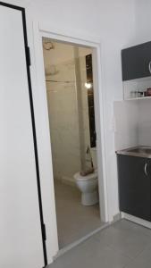 a bathroom with a toilet and a glass doorway at Афіни Лофт in Piraeus +2 photos