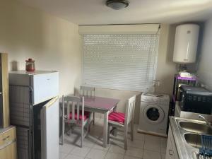 a kitchen with a table and a washing machine at Kaz'a Diamant in Le Diamant
