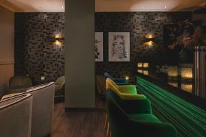 a waiting room with green chairs and brick walls at Leonardo Hotel Heidelberg City Center in Heidelberg