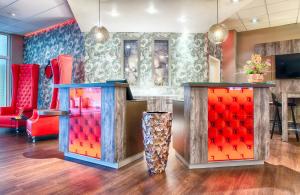 a room with two red chairs and two tables at Leonardo Hotel Mannheim-Ladenburg in Ladenburg