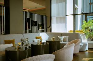a living room with two tables and a couch at Leonardo Royal Hotel Munich in Munich +47 photos