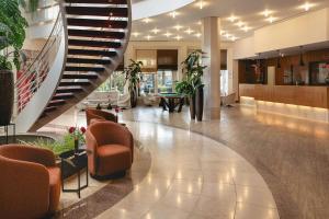 a lobby with chairs and stairs in a building at Leonardo Hotel Weimar in Weimar +72 photos