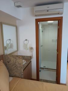a bathroom with a shower and a sink and a mirror at Apart no Hotel Saint Moritz n° 810 in Brasília