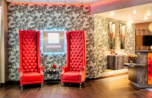 two red chairs in a room with a wall at Leonardo Hotel Mannheim-Ladenburg in Ladenburg +60 photos