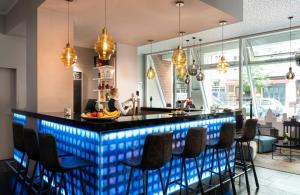 a bar in a restaurant with blue lighting at Leonardo Hotel Berlin in Berlin